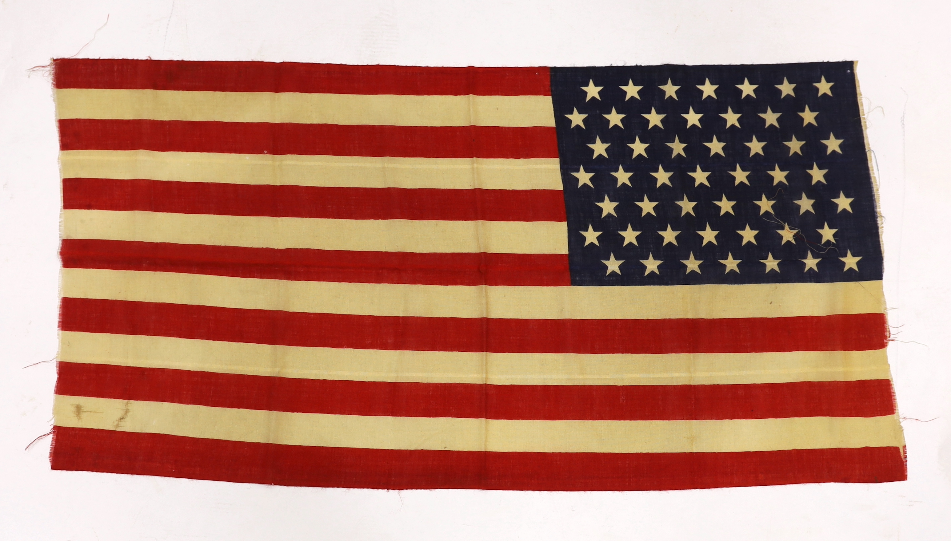 A 1959 USA flag, ‘Stars and Stripes’ printed on light open woven material, forty-nine stars, seven red stripes and six white stripes, 70 x 138cm